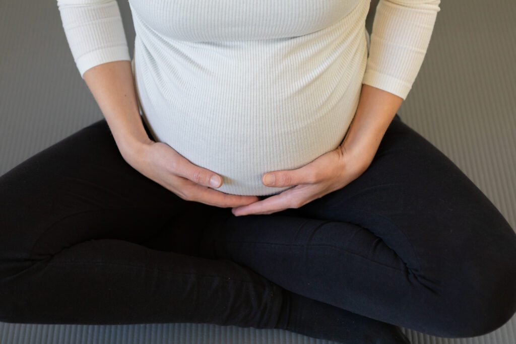 Aufnahme einer schwangeren Frauen im Schneidersitz auf Yogamatten